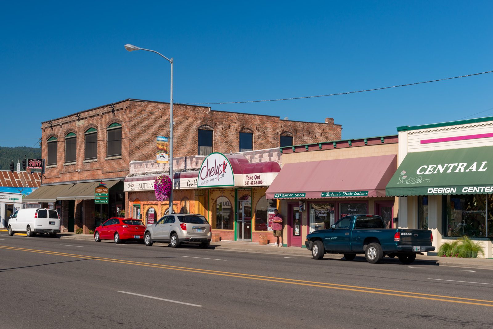 Downtown Central Point, a main street with brick storefronts and awnings under a clear blue sky